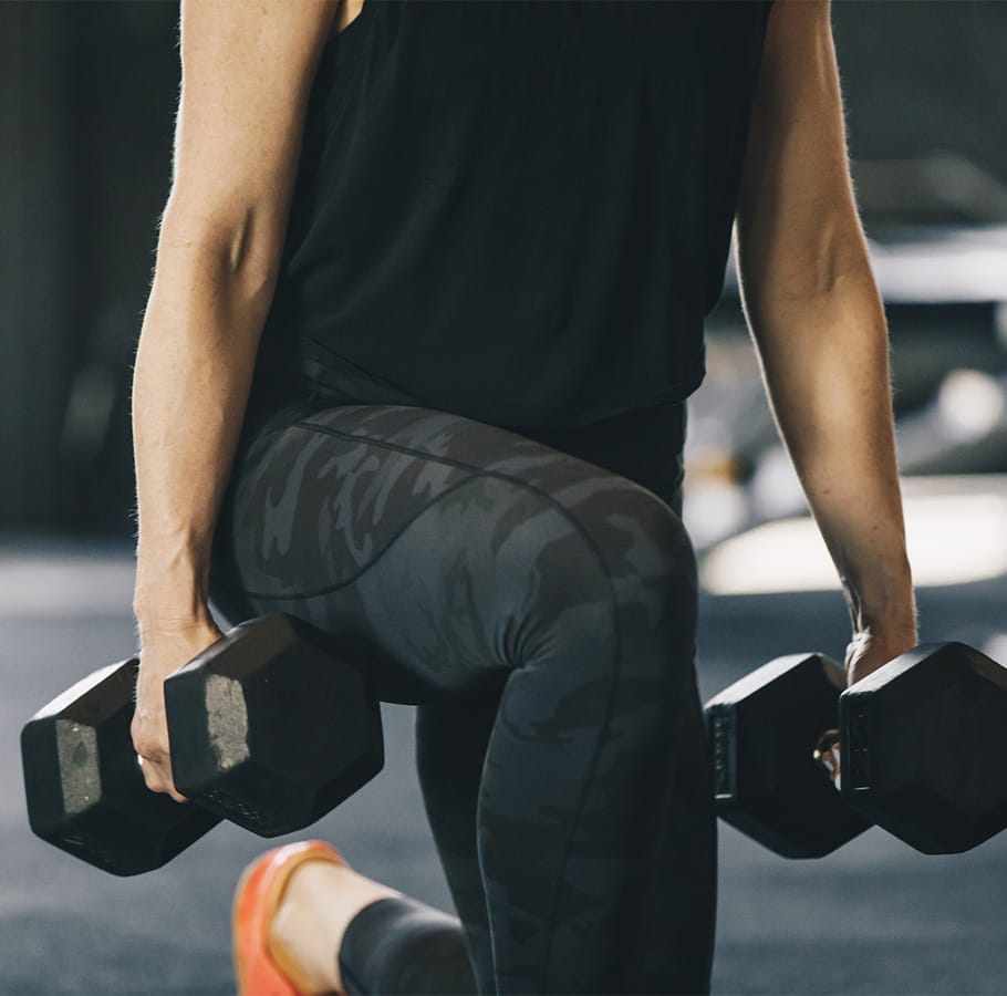 About 1 woman doing leg extentions with dumbbells